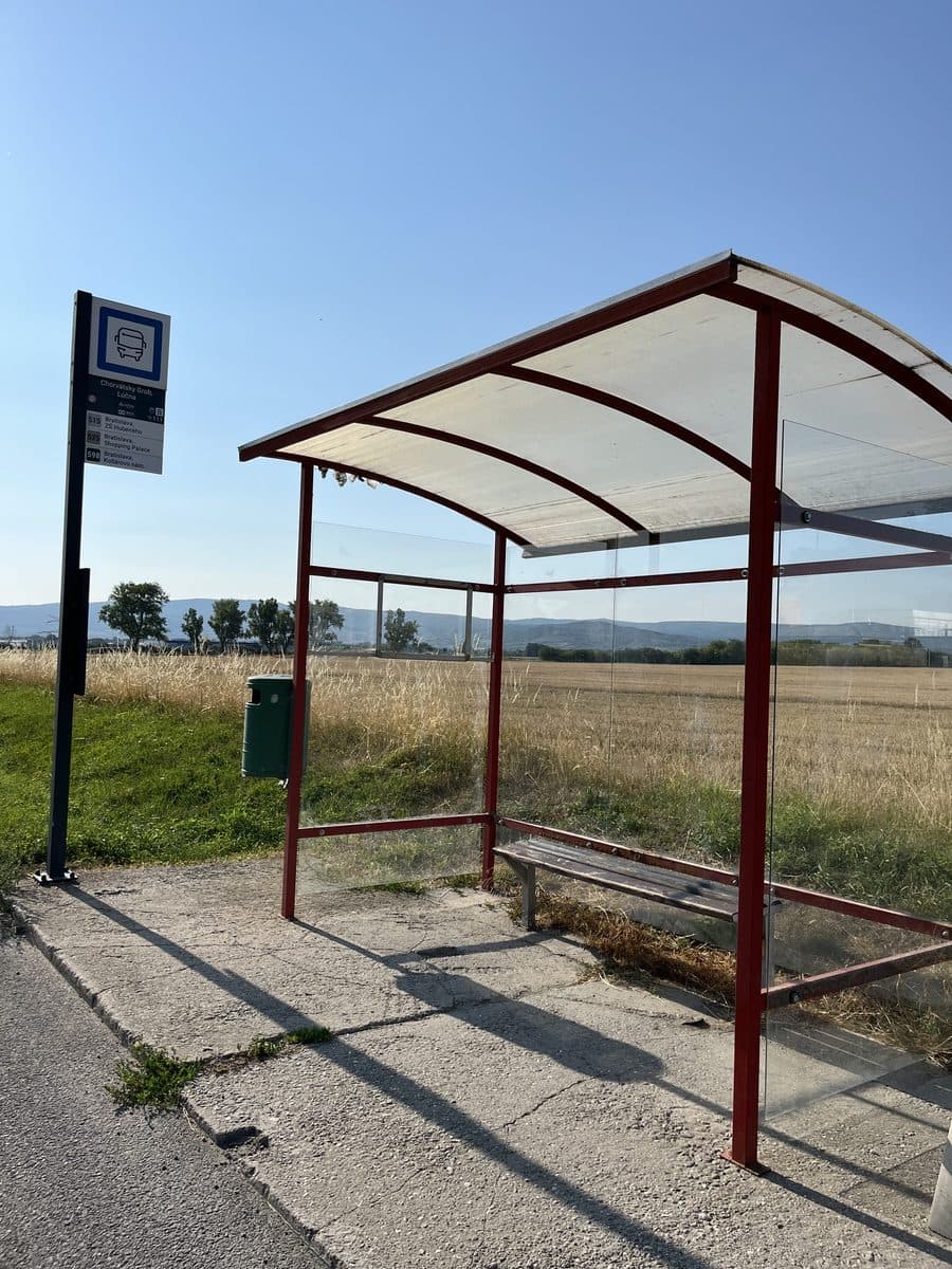 Krytá autobusová zastávka pri poli, 5 minút chôdze od pozemkov